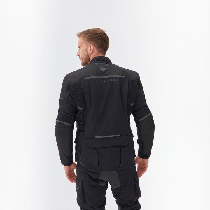 Man bakifrån iklädd Rebelhorn Textil Mc-Jacka Range Svart, visande jackans passform och design för motorcykelåkning.